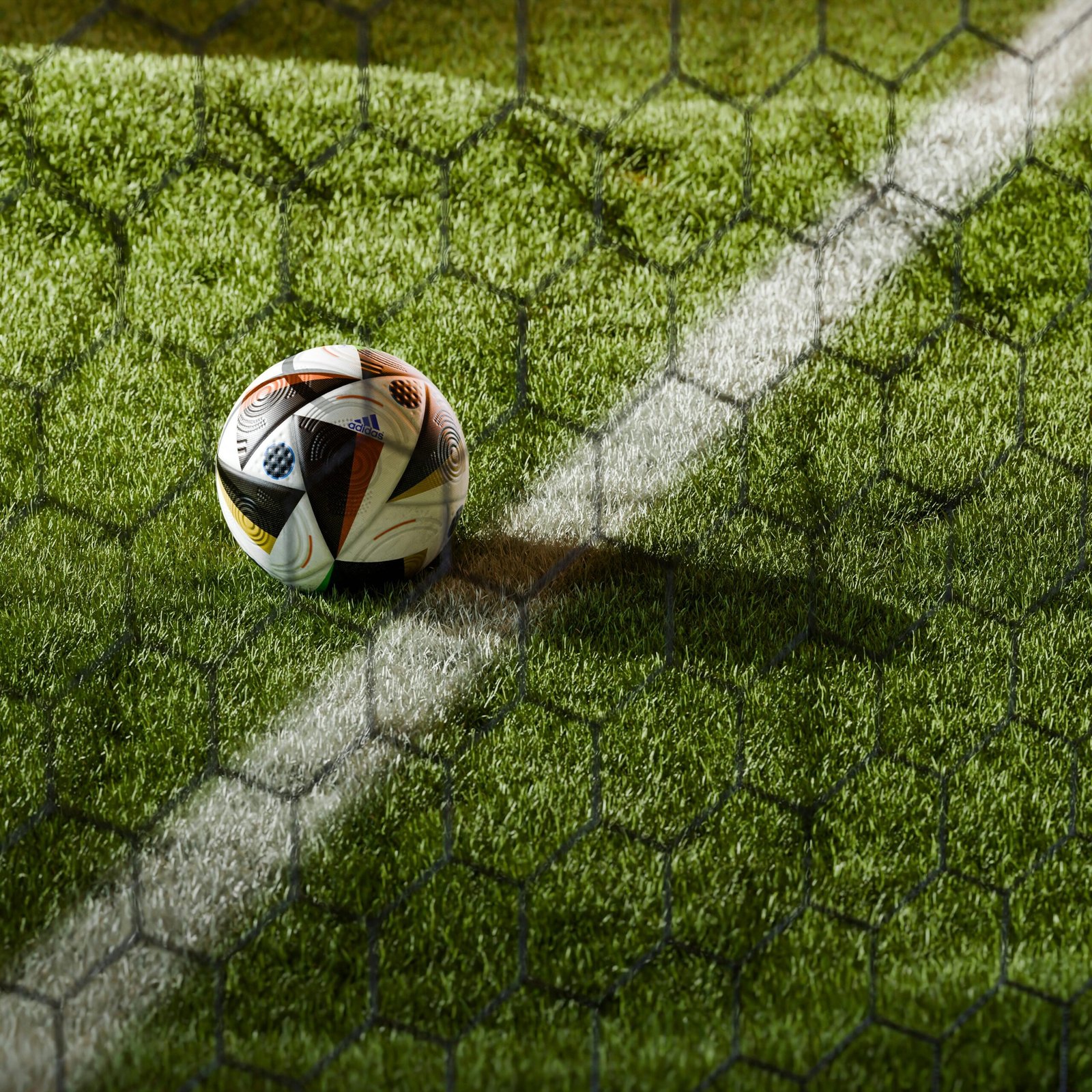 Soccer ball on a lush green field seen through netting, perfect for sports themes.